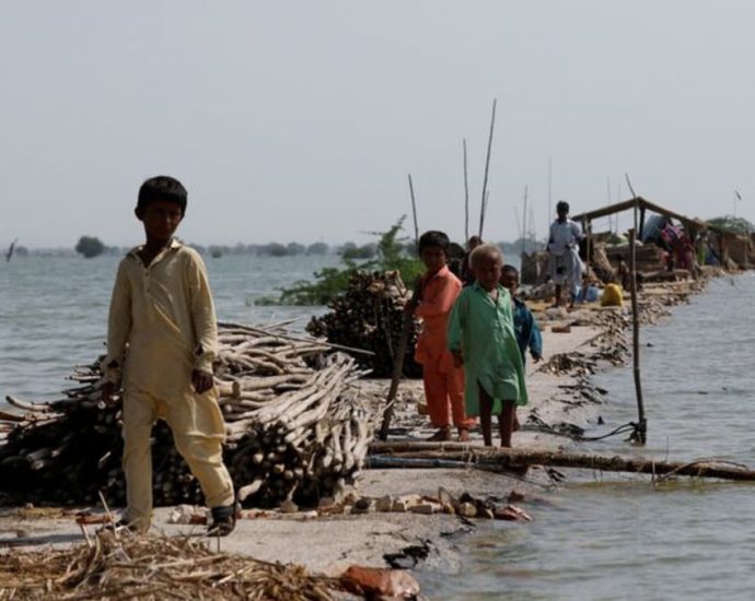 Pakistanis throw up barriers against rising floodwaters; 12 more die