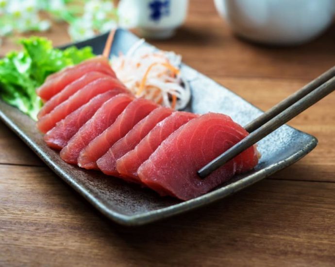 How do food outlets and delivery providers ensure that raw fish is safe to consume?