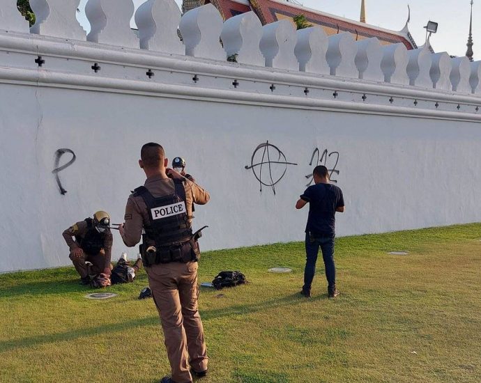 Man charged after painting protest message on Wat Phra Kaew wall