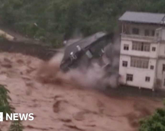 Building collapses into raging China floodwaters