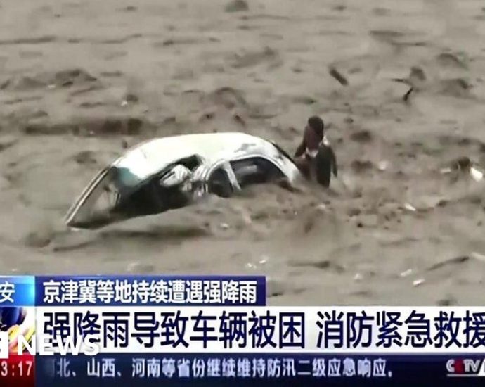 Man saved after car flips in raging floodwaters